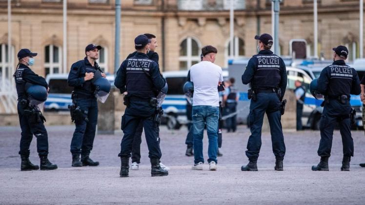 Polizisten stehen bei einer Personenkontrolle auf dem Schlossplatz. Nach den vor kurzem stattgefundenen Krawallen in Stuttgart, kontrolliert die Polizei verstärkt Bereiche in der Innenstadt.