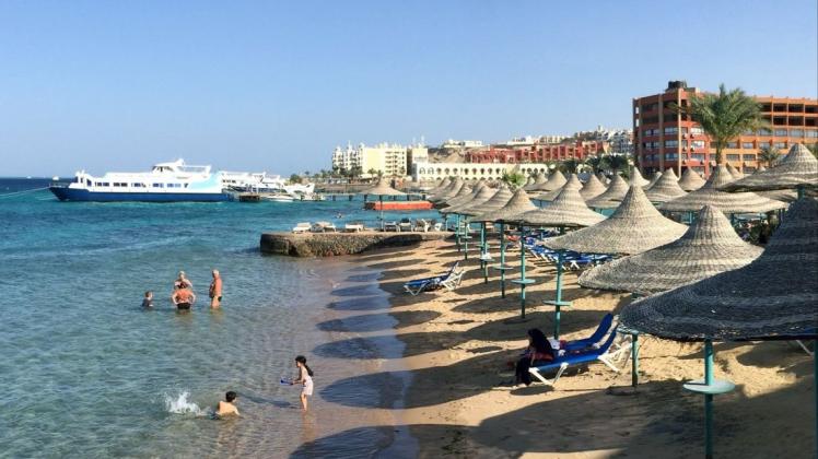 Touristen stehen im Wasser an einem Hotel-Strand. Urlaub ist in der Corona-Pandemie in vielen Ländern Europas wieder möglich.