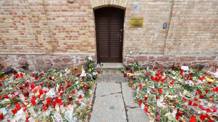 Einer der Tatorte: Nur noch ein schmaler Weg führt zwischen den Blumen und Kerzen zur Tür der Synagoge Halle.