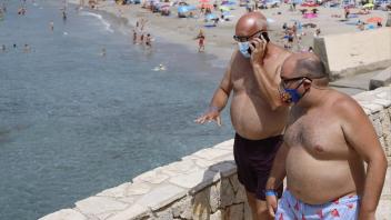 Mittlerweile ein Vertrautes Bild: Maskenträger am Strand von Palma.