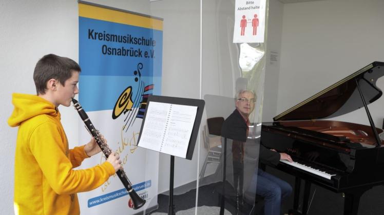 Der 14-jährige Schüler Konstantin Stutzky (Klarinette) und Dirk Anacker (Klavier) sind mit einem sogenannten Spuckschutz beim Proben in der Musikschule in Belm voneinander getrennt.