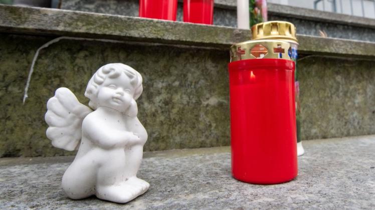 Kerzen und ein kleiner Engel stehen vor dem Hauseingang eines Hauses. Nach dem Fund von zwei toten Kindern in Niederbayern steht ihr Vater unter Tatverdacht.