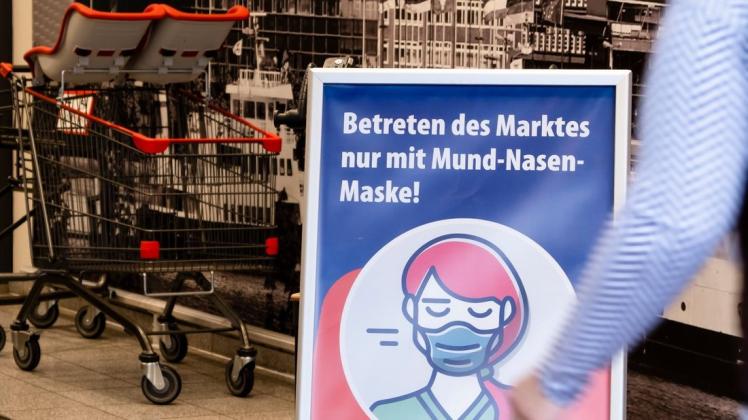 Ein Schild am Eingang eines Supermarkts in Kiel weist auf die Maskenpflicht hin. Foto: Frank Molter/dpa