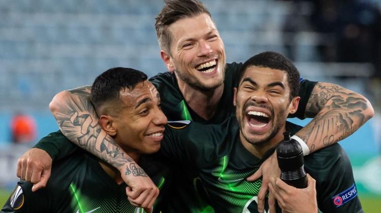 Eine Runde weiter: Wolfsburgs Joao Victor (l-r),  Daniel Ginczek und Paulo Otavio jubeln nach dem Spiel. Foto: dpa/Swen Pförtner
