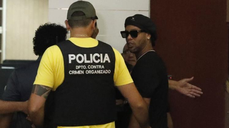 Der ehemalige brasilianische Fussballstar Ronaldinho (r) trifft in Paraguays Staatsanwaltschaft in Asuncion ein. Foto: Jorge Saenz/AP/dpa