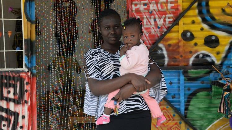 Melody Mmboga steht mit ihrer einjährigen Tochter Praise vor einem Laden in einem Slum. Die 20-Jährige verdient nur umgerechnet 36 Euro im Monat und kann sich oft keine Binden leisten. Foto: dpa/Gioia Forster