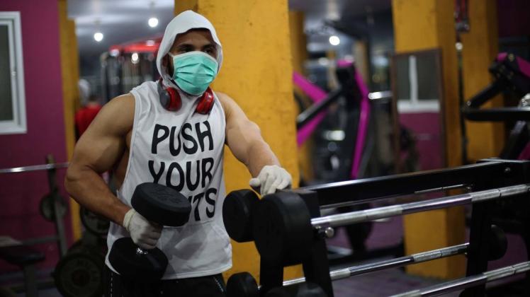 Aus Angst vor dem Coronavirus trainieren die Menschen in einigen Fitnessstudios nur noch mit Mundschutz. Foto: imago images/ZUMA Wire