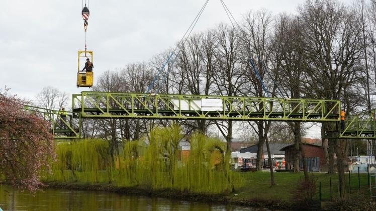 Umfangreiches Manöver: Mithilfe von zwei Kränen wurde das Mittelteil der Fußgängerbrücke am Dortmund-Ems-Kanal über die Baumkronen auf den bereitstehenden Sattelschlepper auf der Schülerwiese gehoben. Foto: Tim Gallandi