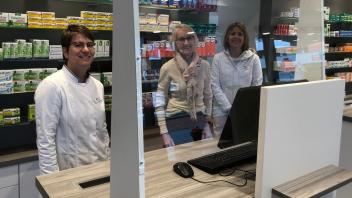Effektive Maßnahme:  Apothekerin Helgard von Mletzko-Sudhoff und ihre Mitarbeiterinnen Claufia Rüffer und Sandra Badena an der Glasscheibe im Verkaufsraum. 