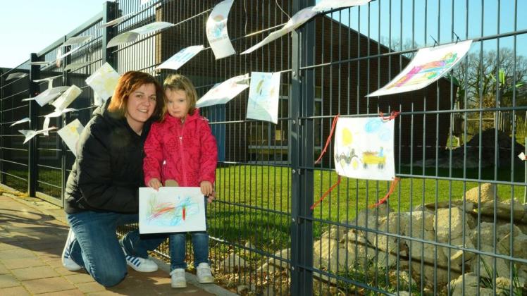 Auch die kleine Josie beteiligte sich an der Malaktion und befestigte mit ihrer Mutter Rosalie ein Bild an der Spielplatzpforte des Marien-Kindergarten.
Foto: Georg Geers