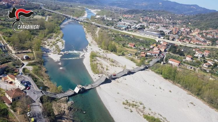 Die von der Polizei zur Verfügung gestellte Luftaufnahme zeigt die eingestürzte Brücke über einem Fluss. Foto: Carabinieri/dpa Die von der Polizei zur Verfügung gestellte Luftaufnahme zeigt die eingestürzte Brücke über einem Fluss. Foto: Carabinieri/dpa