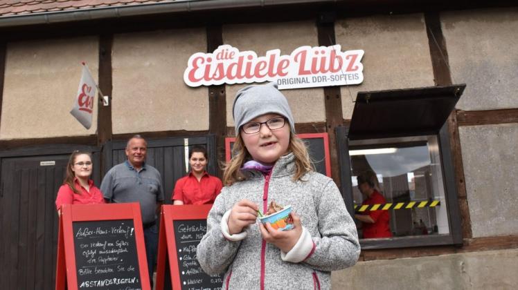 Süße Osterfreuden aus dem Becher: Jenny Klein genießt das DDR-Softeis von der Lübzer Eisdiele. Das Amtsturm-Team im Hintergrund freut sich auf seine Gäste an den Feiertagen.