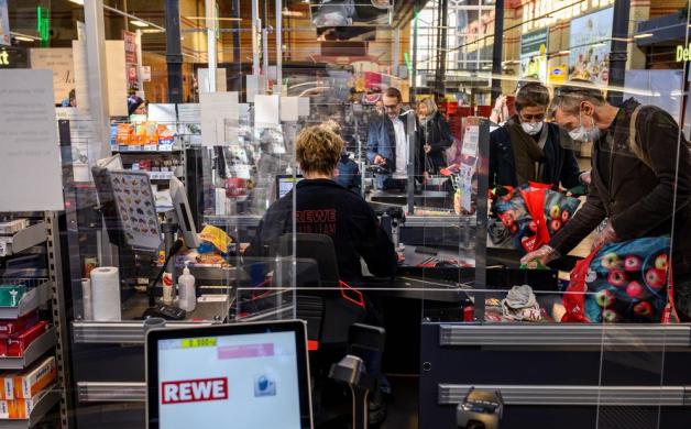 Kassierer hinter Plexiglas: Tausende Beschäftigte in Deutschland riskieren während dieser Pandemie Kundenkontakt, damit die "systemrelevanten" Prozesse in Deutschland am Laufen bleiben. Foto: AFP/John MACDOUGALL