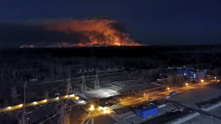 Am Horizont steigen Rauchschwaden von einem Waldbrand in der radioaktiv belasteten Sperrzone um das Kernkraftwerk Tschernobyl auf.