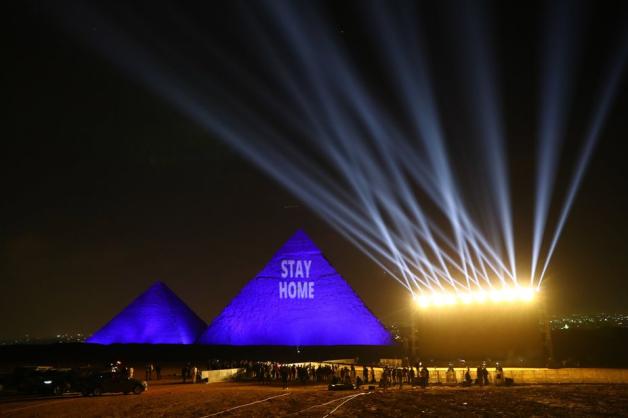 Eine der Pyramiden von Gizeh wird zum  Welterbetag mit den Worten "Stay Home" angestrahlt.