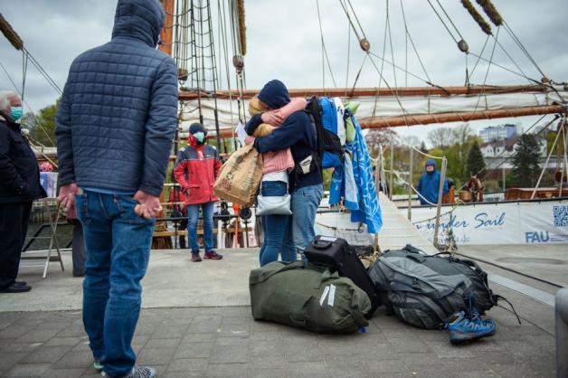 Eine Mutter umarmt Ihren Sohn nach der Ankunft des Segelschiffes im Kieler Hafen. 