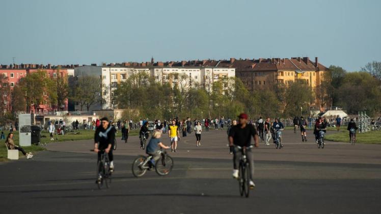 Zahlreiche Menschen sind zu Fuß und auf dem Fahrrad auf dem Tempelhofer Feld in Berlin unterwegs.