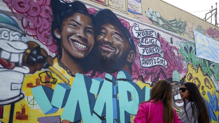 In Los Angeles stehen Fans vor einem Wandgemälde, das den Basketballspieler Kobe Bryant und dessen Tochter zeigt. Beide verunglückten vergangenen Sonntag bei einem Helikopter-Absturz. Foto: dpa/David Crane/The Orange County Register