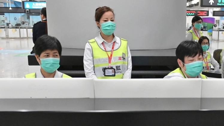 Mitarbeiter des Honkonger Gesundheitswesens untersuchen am Bahnhof West Kowloon Station Reisende auf ihren Gesundheitszustand hin. Foto: dpa/Informationsdienst der Hongkonger Regierung