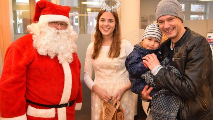 Auch die dreijährige Maja wurde vom Weihnachtsmann und Engel Julia Indorf beschenkt. Auf dem Arm von Papa Maik Gnädig sang Maja das Lied „In der Weihnachtsbäckerei“. Foto: Dirk Hamm