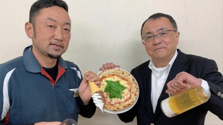 Fabrikleiter Hiroaki Miyazawa (l.) und Firmensprecher Yuta Kurokawa mit Repliken: eine Pizza, eine Maß Bier, eine Cola mit Eiswürfeln während des Einschüttens und ein Softeis. 