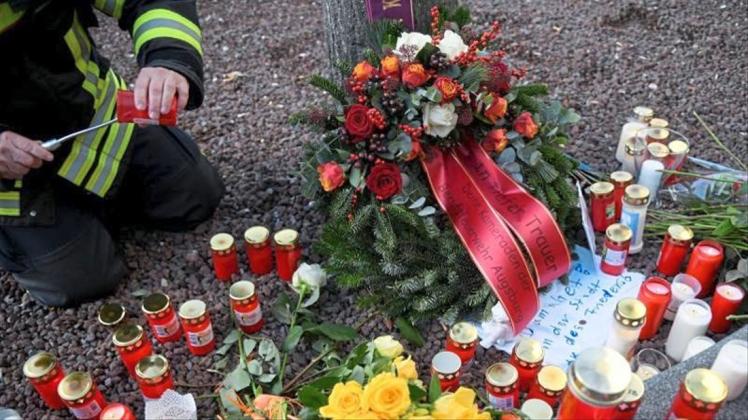 Zur Erinnerung an das Opfer zündet ein Feuerwehrmann am Königsplatz in Augsburg eine Kerze an. 