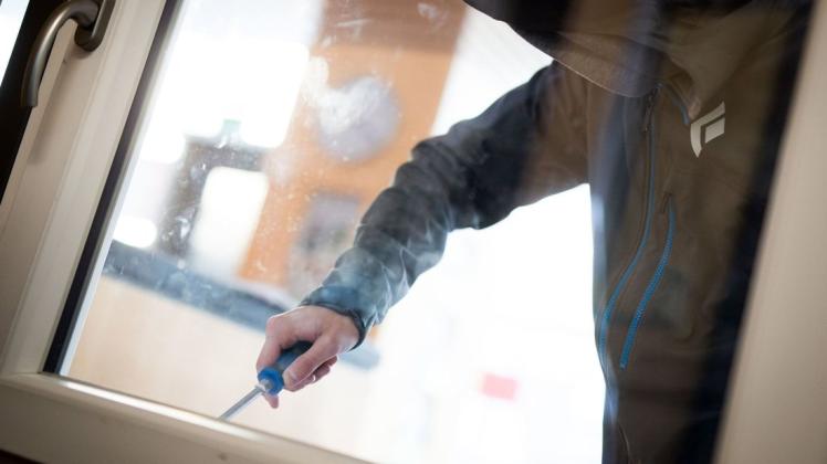 Ein Mann demonstriert in der polizeilichen Beratungsstelle, wie einfach es für einen Einbrecher wäre, mit Hilfe eines stabilen Schraubenziehers ein geschlossenes Fenster von außen zu öffnen.  Foto: Frank Rumpenhorst/dpa