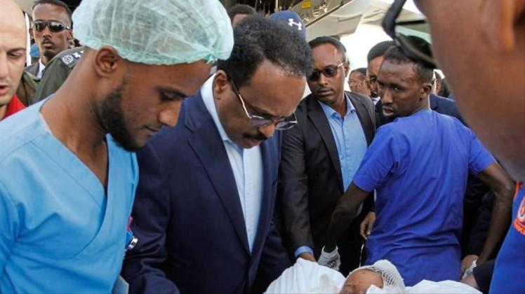 Somalias Präsident Mohamed Abdullahi Mohamed (Mitte l) besucht Opfer, die bei der Explosion einer Autobombe am 28.12.2019 verletzt wurden. 