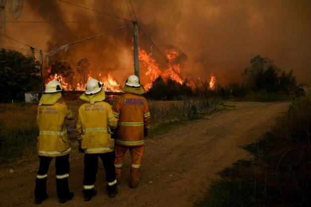 21.12.2019: Feuerwehrmänner des RFS (Rural Fire Service) beobachten das übergreifende Feuer auf den Landwirtschaftsbetrieb "Bilpin Fruit Bowl".