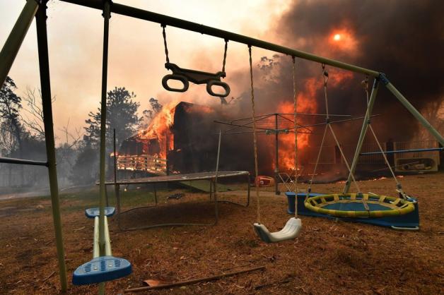 19.12.2019: Ein Haus steht südwestlich von Sydney in Flammen, davor sind Spielgeräte im Garten zu sehen.