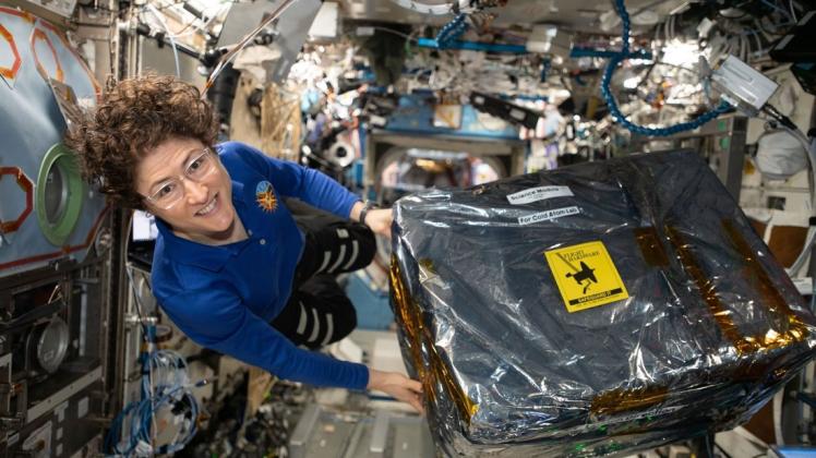Sieht aus wie ein großes Geschenkpaket, ist aber nur wissenschaftliches Equipment: Astronautin Christina Koch im Dezember 2019 auf der ISS. Foto: NASA