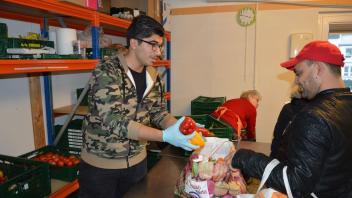 IGS-Schüler Bashkim Jneid versorgt einen Kunden mit Gemüse. Fotos: Martin Heuer