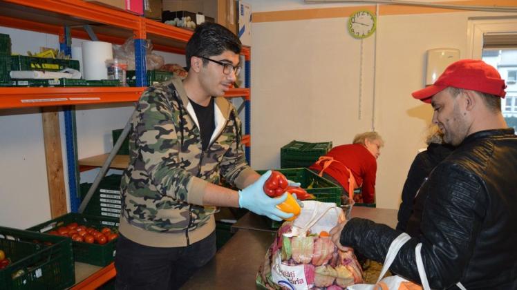 IGS-Schüler Bashkim Jneid versorgt einen Kunden mit Gemüse. Fotos: Martin Heuer