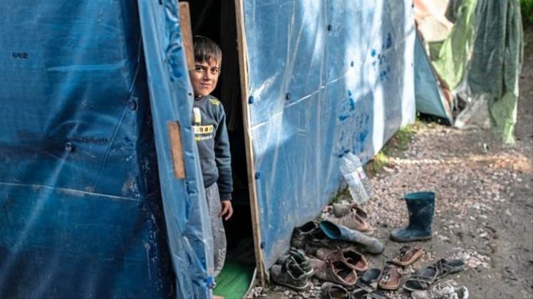 Ein Kind schaut aus einem Zelt im Flüchtlingslager Vial. 
