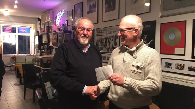 Taxi-Harry aus Warnemünde überreicht Klaus Möller vom Leuchtturm-Verein einen Umschlag mit 300 Euro. Harry Stutz hat sein Fahrrad zugunsten der Aktion "Sei Turmleuchter" versteigert.