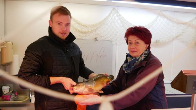 Einer der letzten Karpfen geht im Fischmobil von Karla Zimmermann über die Theke, die Nachfrage ist hoch. Kollege Michael Bruß hilft beim Verkauf.