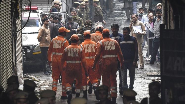Mitglieder der Spezialeinheit "National Disaster Response Force" (NDRF India) im Einsatz am Fabrikgebäude, in dem es gebrannt hat. Foto: dpa/Str/XinHua