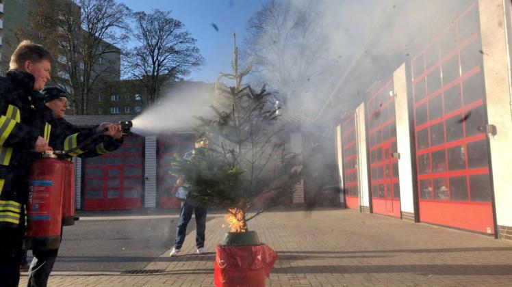 Demonstrieren, wie schnell ein Baum brennt – und löschen umgehend: Nick Bäker (li.) und Helmut Punke von der Berufsfeuerwehr. Foto: Jan Eric Fiedler