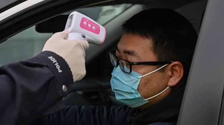 fa8bd2e6906d3f925cc65171fcb3c89c.jpeg Fieber messen am Checkpoint: Chinas Behörden versuchen mit drastischen Maßnahmen die Corona-Epidemie einzudämmen. Denn sie könnte sich negativ auf die Wirtschaft im Land auswirken. Foto: Hector Retamal/AFP