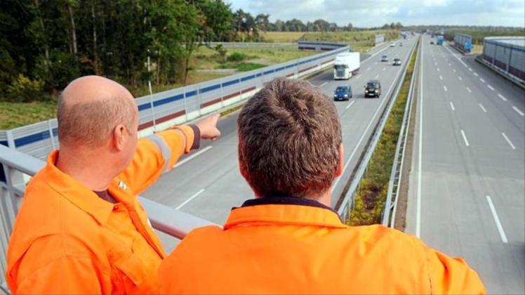 Mitarbeiter des privaten Konsortiums A1 mobil stehen auf einer Brücke über der A1 zwischen Hamburg und Bremen. 