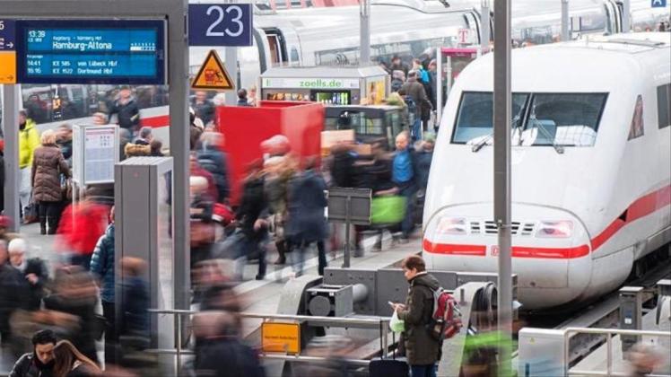 Reisende gehen am Münchner Hauptbahnhof über eine Plattform. 