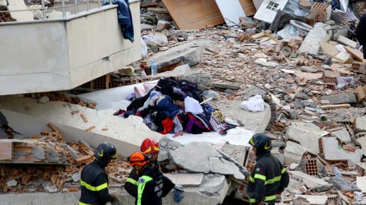 Italienische Rettungskräfte stehen vor einem bei einem schweren Erdbeben eingestürzten Haus. Foto: dpa/Hektor Pustina