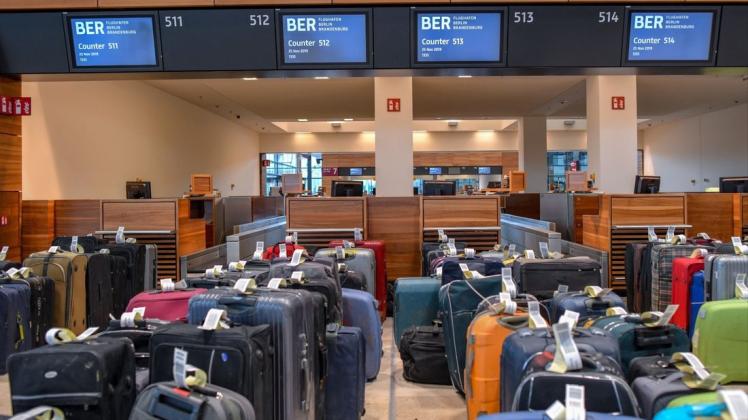 Viele Reisekoffer stehen zu Testzwecken vor Check-in-Schaltern im Terminalgebäude des Hauptstadflughafens Berlin Brandenburg Willy Brandt (BER). Foto: dpa/Patrick Pleul