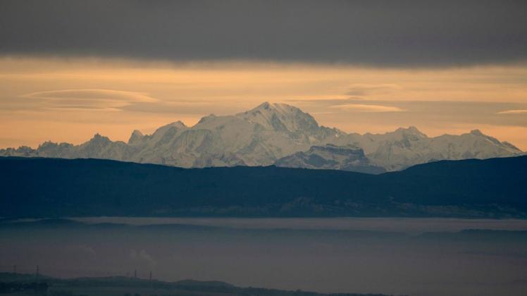 Der Mont Blanc ragt hinter Nebelschwaden am Himmel empor. Foto: dpa/Laurent Cipriani