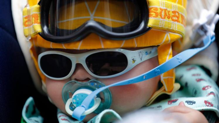 Ein kleines Kind saugt an einem Schnuller, während es bei einer Demonstration in Hongkong eine Sonnenbrille und eine Schutzbrille trägt. In Hongkong kommt es seit zwei Monaten immer wieder zu Protesten und Ausschreitungen. Auslöser für die Demonstrationen war ein Gesetzentwurf zur Auslieferung mutmaßlicher Krimineller an China. Foto: Vincent Thian/AP/dpa