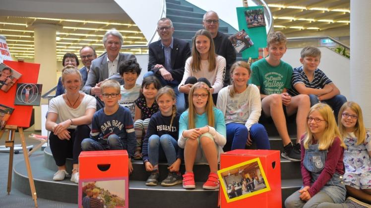 Gemeinsam mit Kindern und Jugendlichen haben jetzt Vertreter der Stadt Lingen und der Sparkasse Emsland die Fotoausstellung zur Lingener Ferienpassaktion in der Filiale der Bank am Markt in Lingen eröffnet. Foto: Wilfried Roggendorf