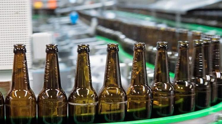 Gewaschene Bierflaschen laufen durch die Produktion einer Brauerei. 