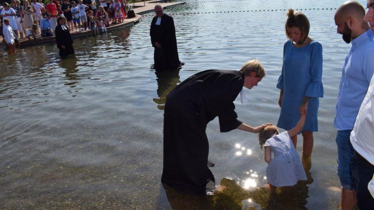 Unter den wachsamen Blicken der Gläubigen und ihrer geistlichen Kollegen nahm Vikarin Esther Staak ihre ersten Taufen in den Fluten des Naturbades vor. Foto Michael Pohl