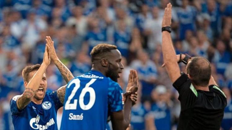 Schalkes Sane (M) und Burgstaller (l) beschweren sich bei Schiedsrichter Fritz über ein nicht gegebenes Handspiel. 