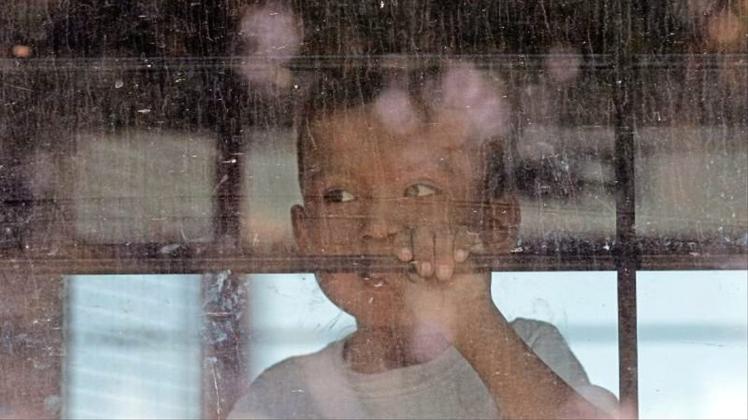 Ein Kleinkind aus einer Familie illegaler Migranten an der Grenze zwischen Mexiko und den USA hinter dem Fenster eines Busses. 